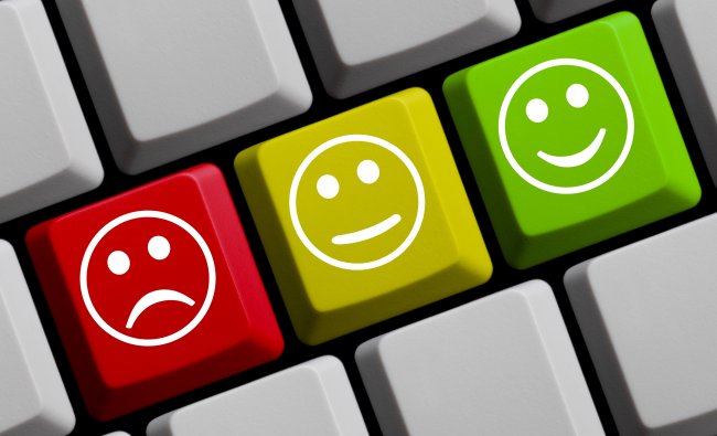 Testimonials concept, sad, content and happy faces on a keyboard